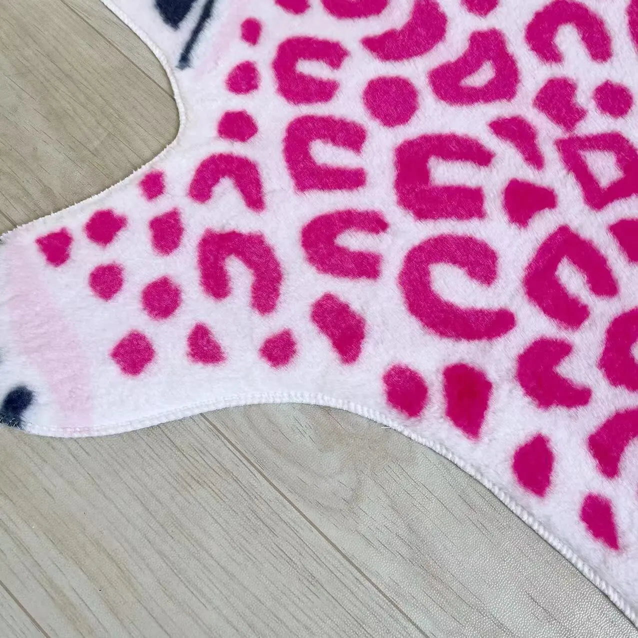 Plush pink imitation leopard rug for decorative use.