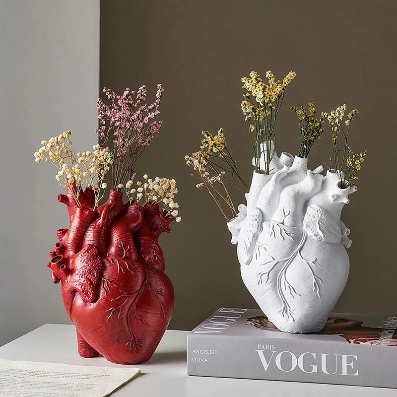 Anatomical heart resin vase with flowers for home décor.