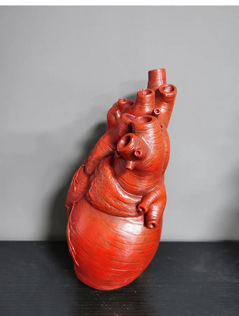 Red heart-shaped resin flowerpot on modern table.