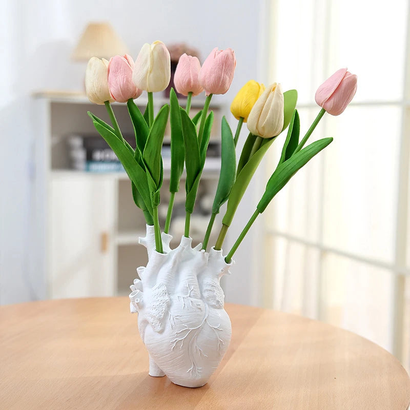 White anatomical heart vase used as floral centerpiece.