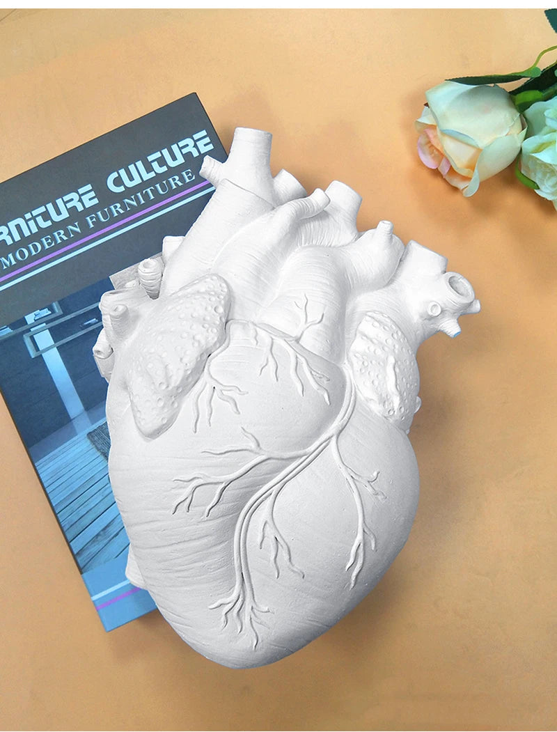 Unique resin heart sculpture holding tulips and flowers.