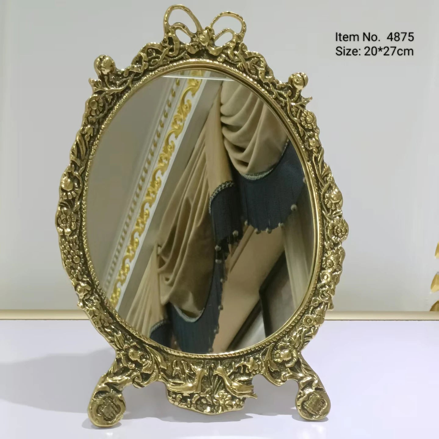 Golden bow elegance mirror with classic ornate stand.