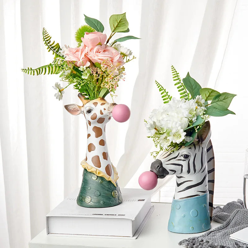 Resin zebra and giraffe vase blowing a bubble for dried flowers on living room table.