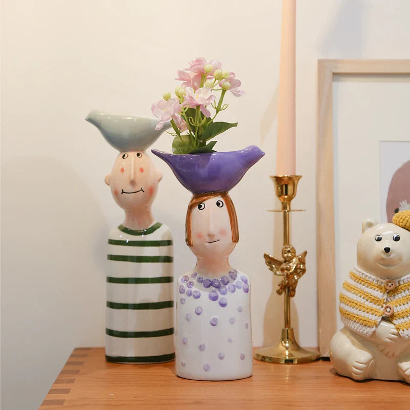 Ceramic boy and girl couple vases with bird design.