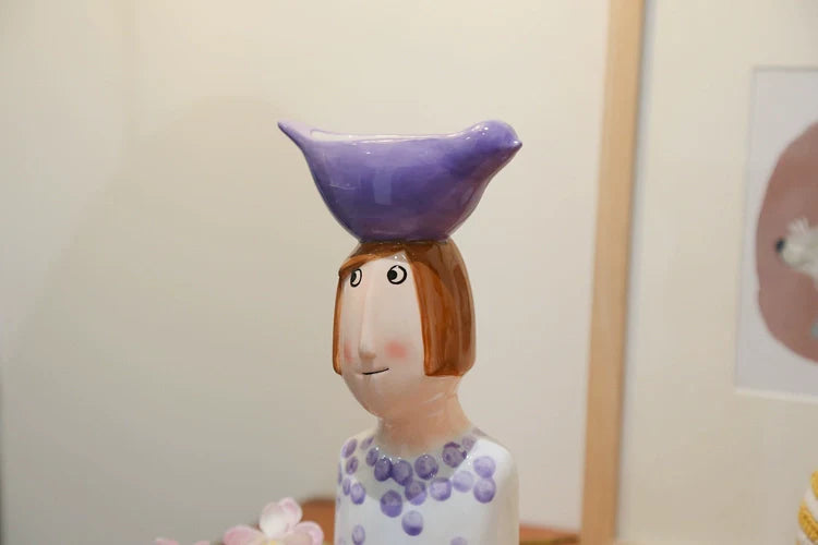 Whimsical ceramic boy vase with striped shirt design.