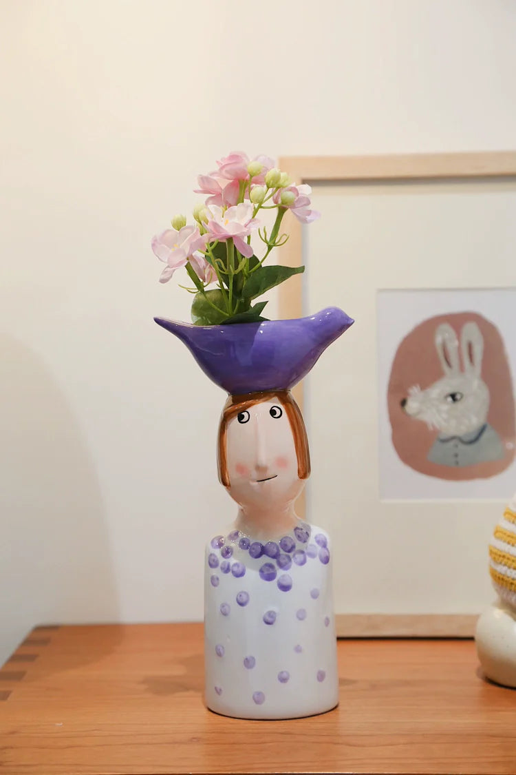 Artistic ceramic girl vase with purple dotted dress.