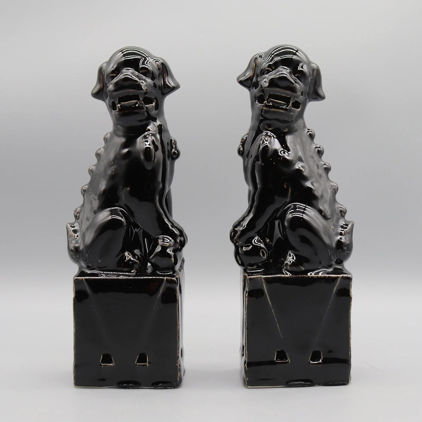 Glossy black ceramic Foo Dogs Chinese guardian lion statues.