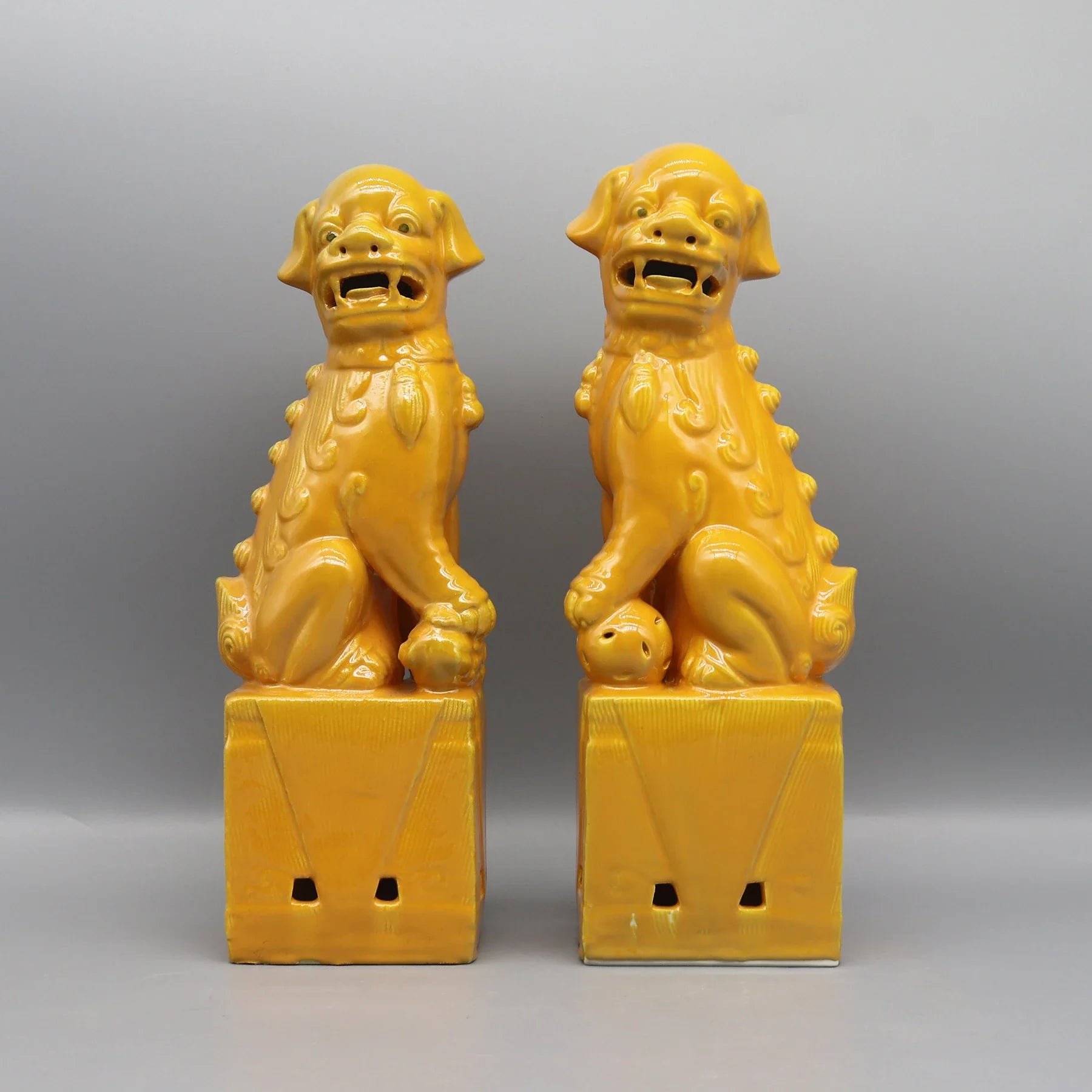Antique-style yellow Foo Dogs ceramic guardian statues.