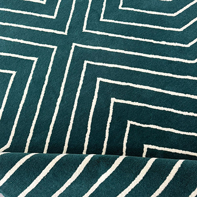 Contemporary geometric wool rug with deep teal tones.