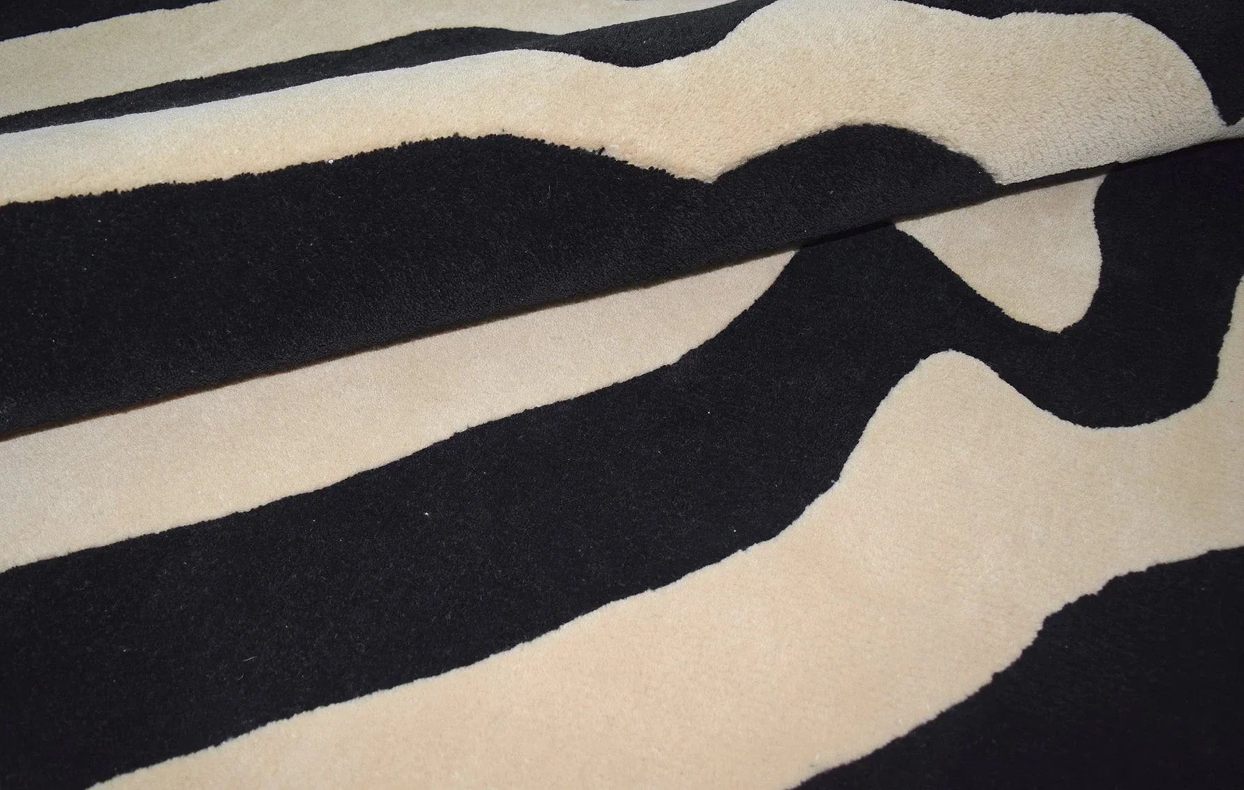 Modern luxury area rug in beige and black tones for stylish home decor.