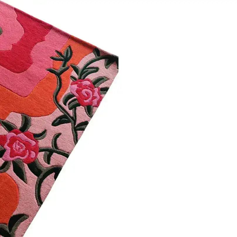 Close-up view of the Floral Wavefront Hand Tufted Area Rug, showcasing a vibrant design with pink and orange floral patterns. Perfect for adding a touch of elegance to living or dining rooms, this wool rug measures 8x10.