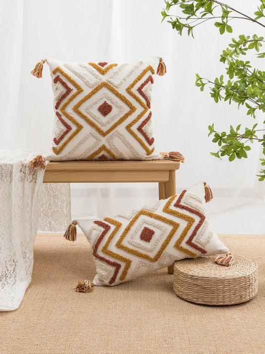 Geometric bohemian throw pillow cover with diamond pattern and tassels.