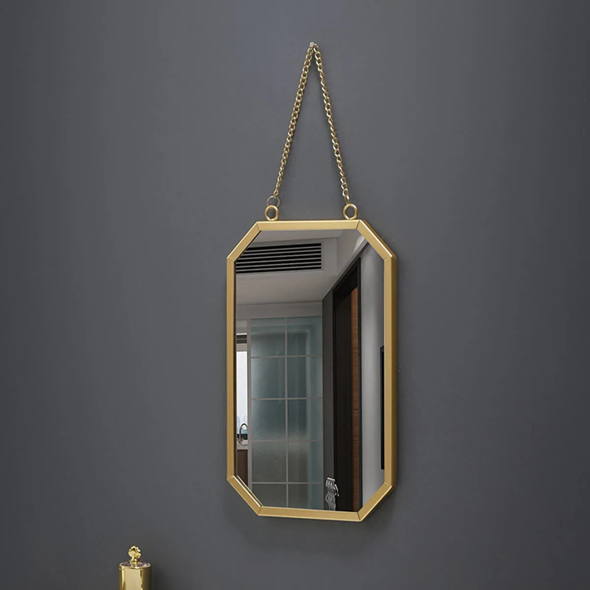 Golden framed rectangular wall mirror with hanging chain for bathroom.