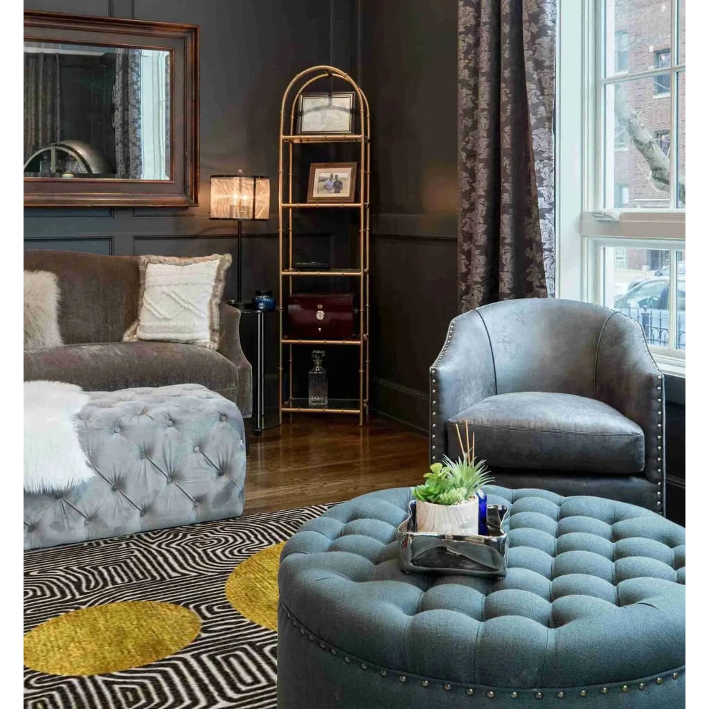 A stylish living room featuring a Three Golden Suns Maze Hand Tufted Wool Area Rug. The large area rug, perfect for living rooms 8x10, showcases a striking geometric design with golden sun patterns. It complements the elegant tufted furniture and sophisticated decor, adding warmth and style to the space.