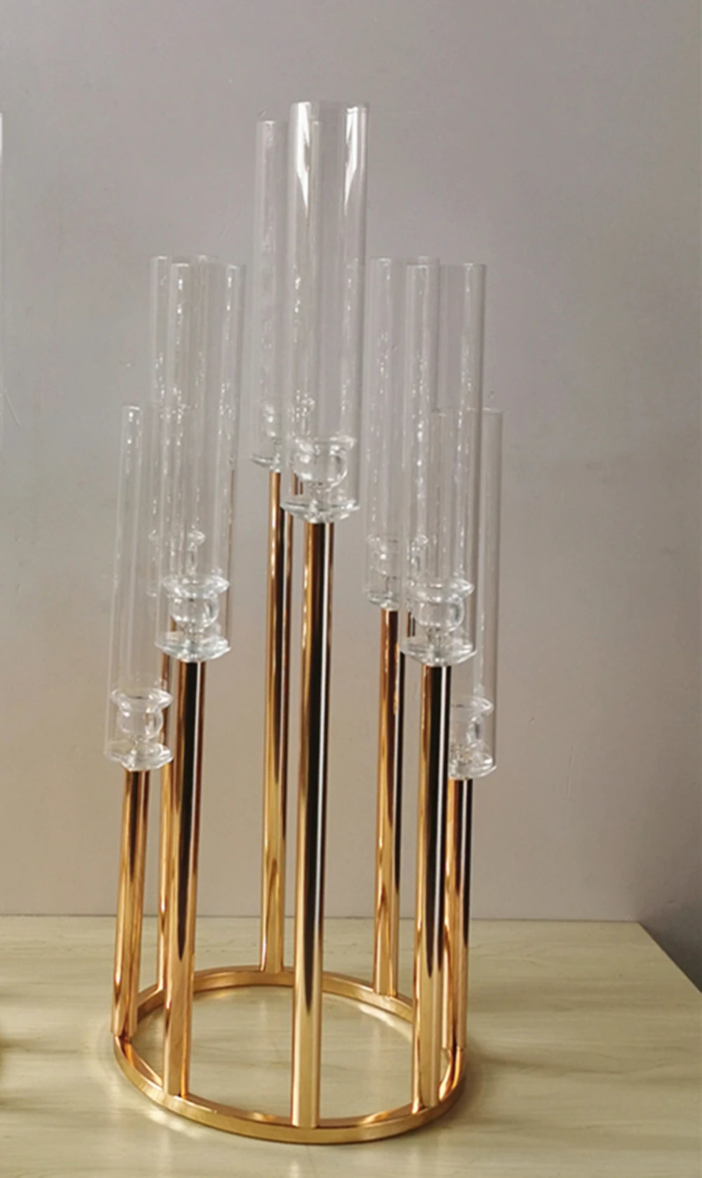 Golden wedding table centerpiece with tall glass tube candle holders.