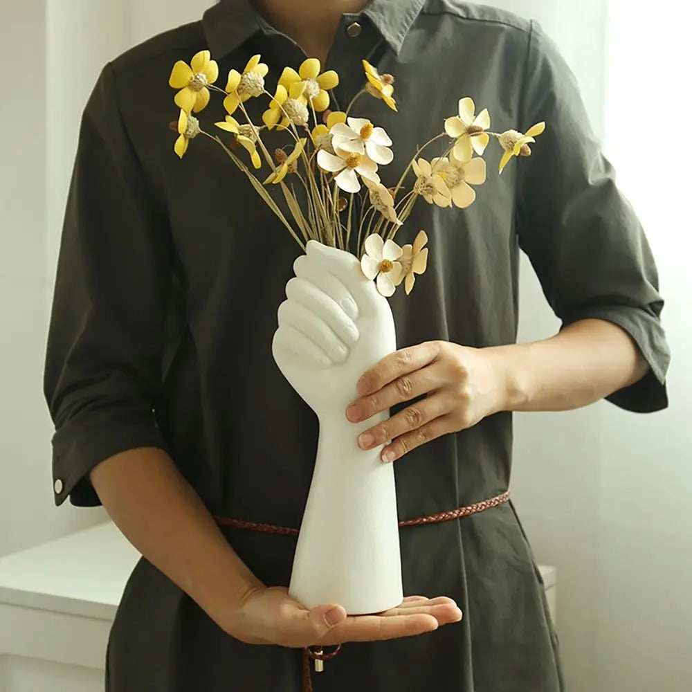 Artistic resin hand vase with minimalist white finish.