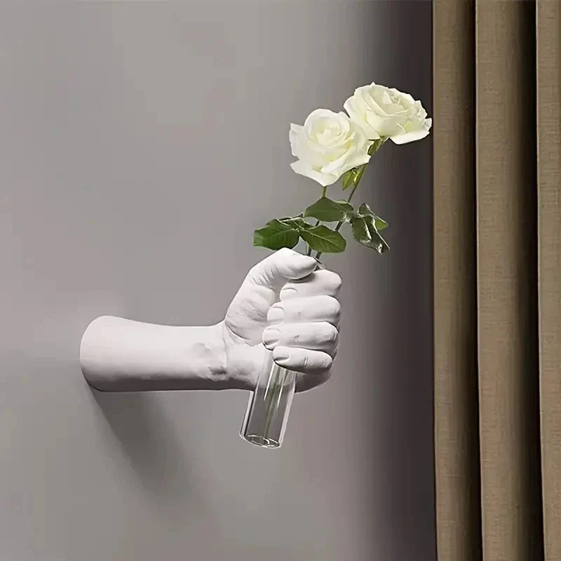 Modern resin wall vase shaped like a hand holding flowers.