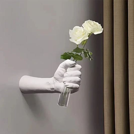 Modern resin wall vase shaped like a hand holding flowers.