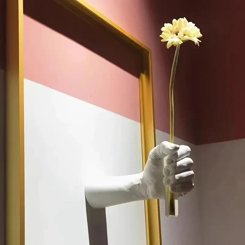 Artistic hand-shaped wall-mounted vase for decorative flowers.