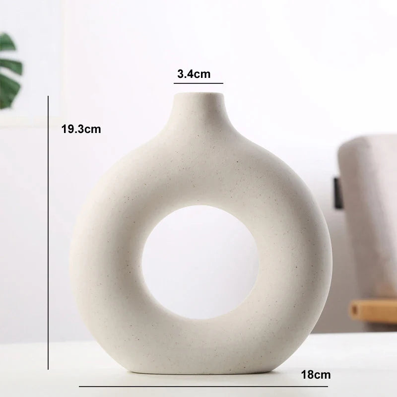 Circular ceramic vase with artistic donut shape.