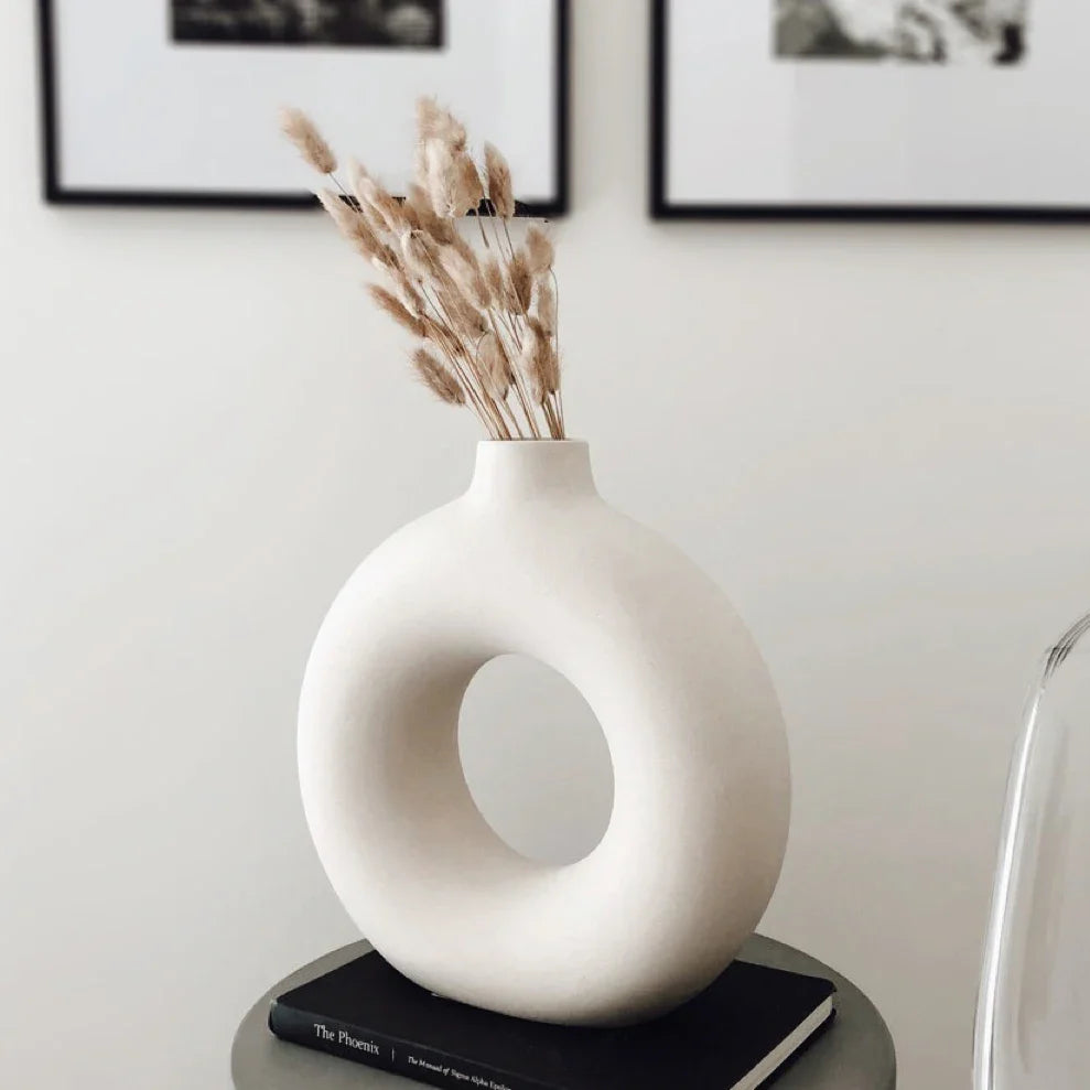 White ceramic round hollow vase for minimalist interiors.
