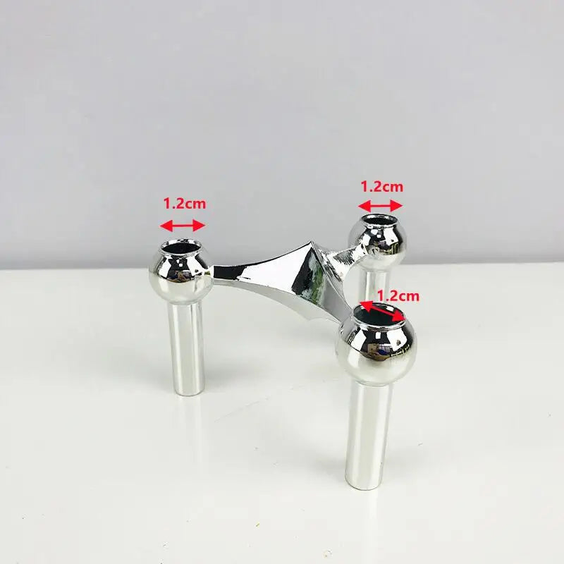 Three-piece silver candle holder set with minimalist structure.
