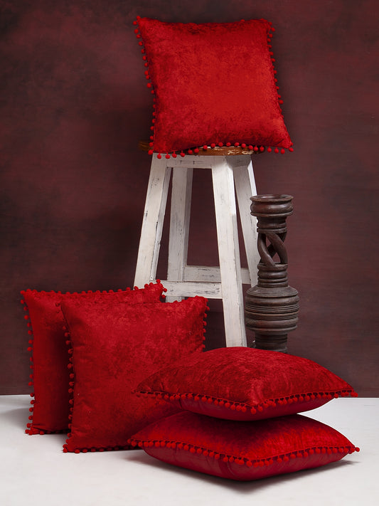 Red velvet pillow covers with pom pom detailing - set of 5 luxury decorative cushions for sofa and bedroom decor.