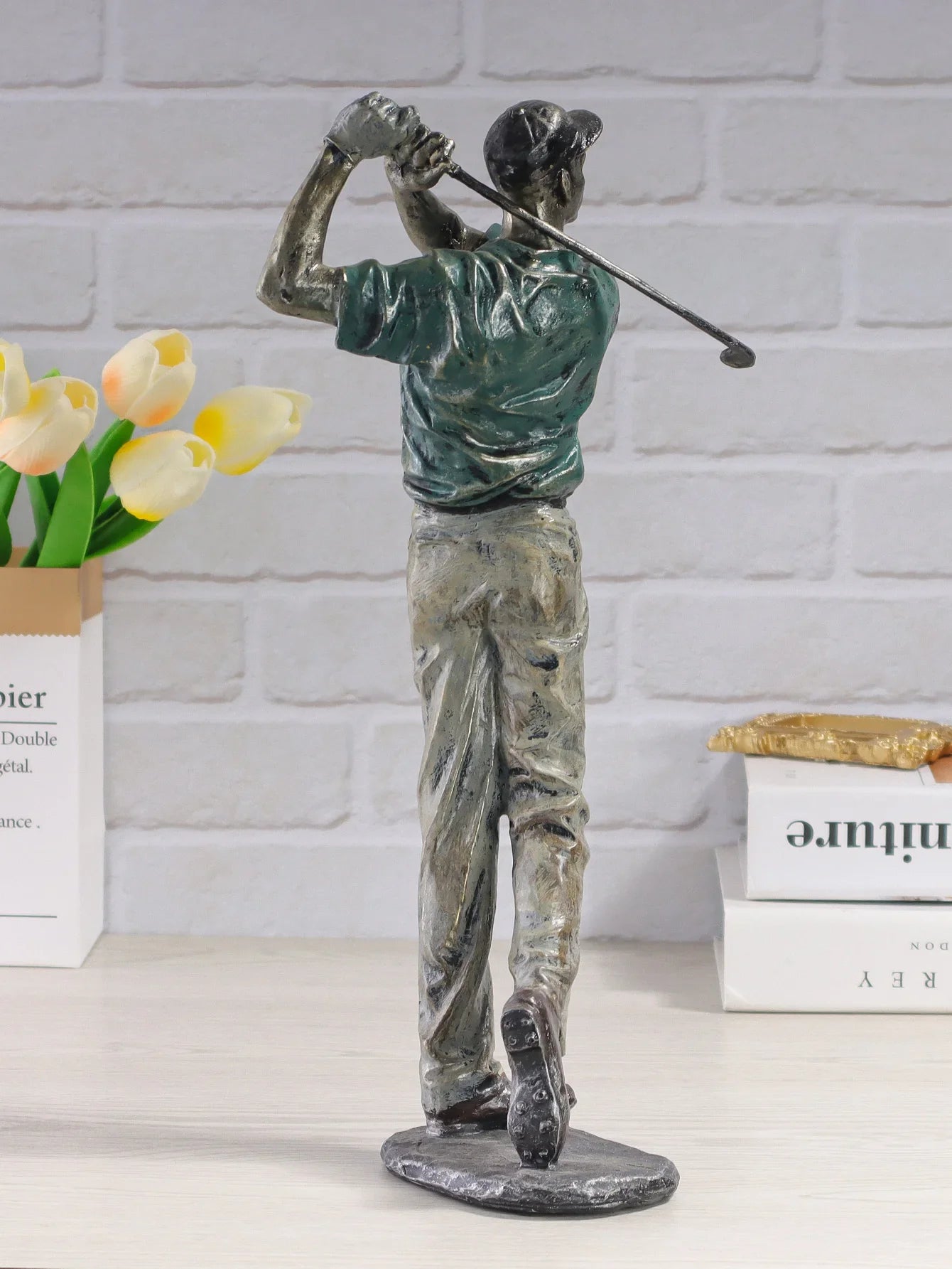 Artistic golfer resin figurine on display table.