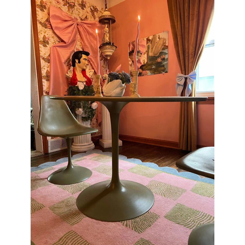 A stylish living room featuring a Scalloped Leaf Checker Pastel Hand Tufted Rug. This large area rug, perfect for a boho-inspired space, showcases a beautiful blend of pink and green checkered patterns with a scalloped border. The wool rug adds a cozy touch to the room, complementing the modern furniture and eclectic decor. Ideal for enhancing large living rooms with a touch of elegance and comfort.