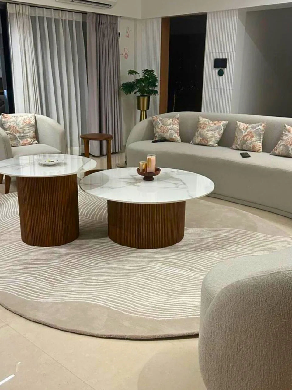 Luxury oval wool rug in beige tones with subtle white linear patterns.