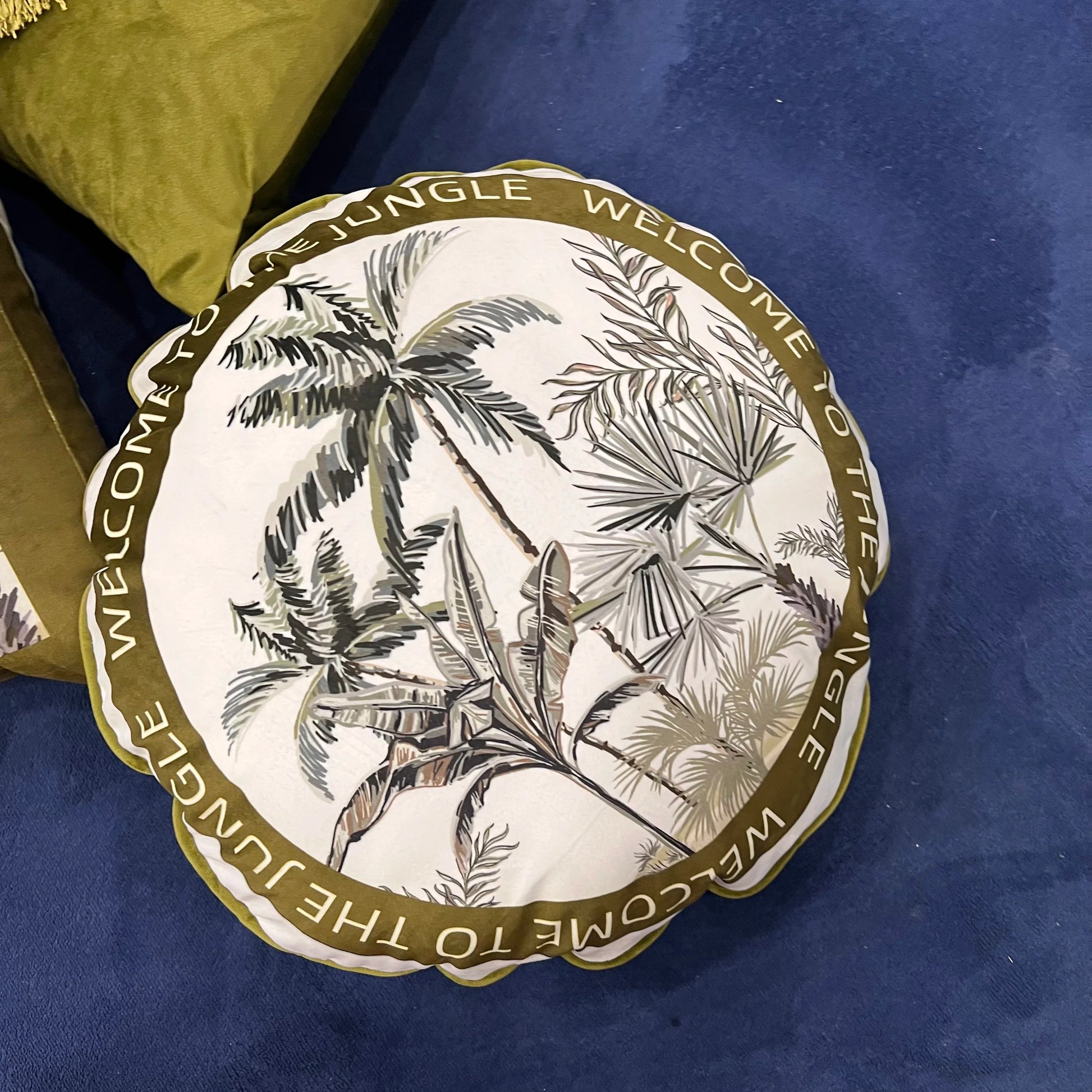 Luxury velvet throw pillow with tropical palm leaf print in olive tones.